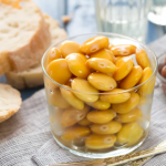 a glass bowl with yellow beans, filled to the top of the bowl.