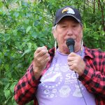 Elder Charlotte Nolin holds up a rose hip.