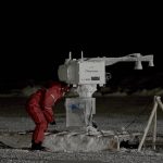 UM researcher Julienne Stroeve looking down at ice to measure thickness in Hudson Bay area.