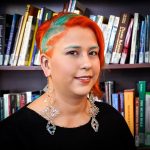 Headshot of Kaila Johnston, NCTR, standing in front of a bookcase