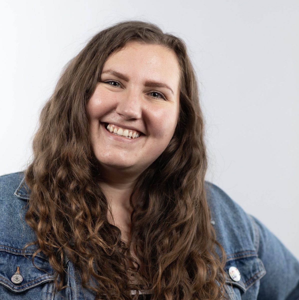 woman smiling and wearing a jeans jacket
