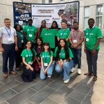 A group of people posing in front of a banner