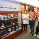 three graduate students talk in the hallway of the Robson Hall Centre for Research and Graduate studies