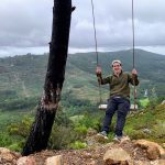 Martin Glikman is on a swing with a lush green valley in the background.