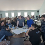 Students gathered around a table looking at building drawings