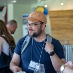 Person smiling while talking with other people in the hallway.