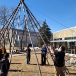 people building a Tipi outside