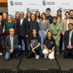 Winners of the 2024 Undergraduate Research Showcase stand and kneel together smiling.