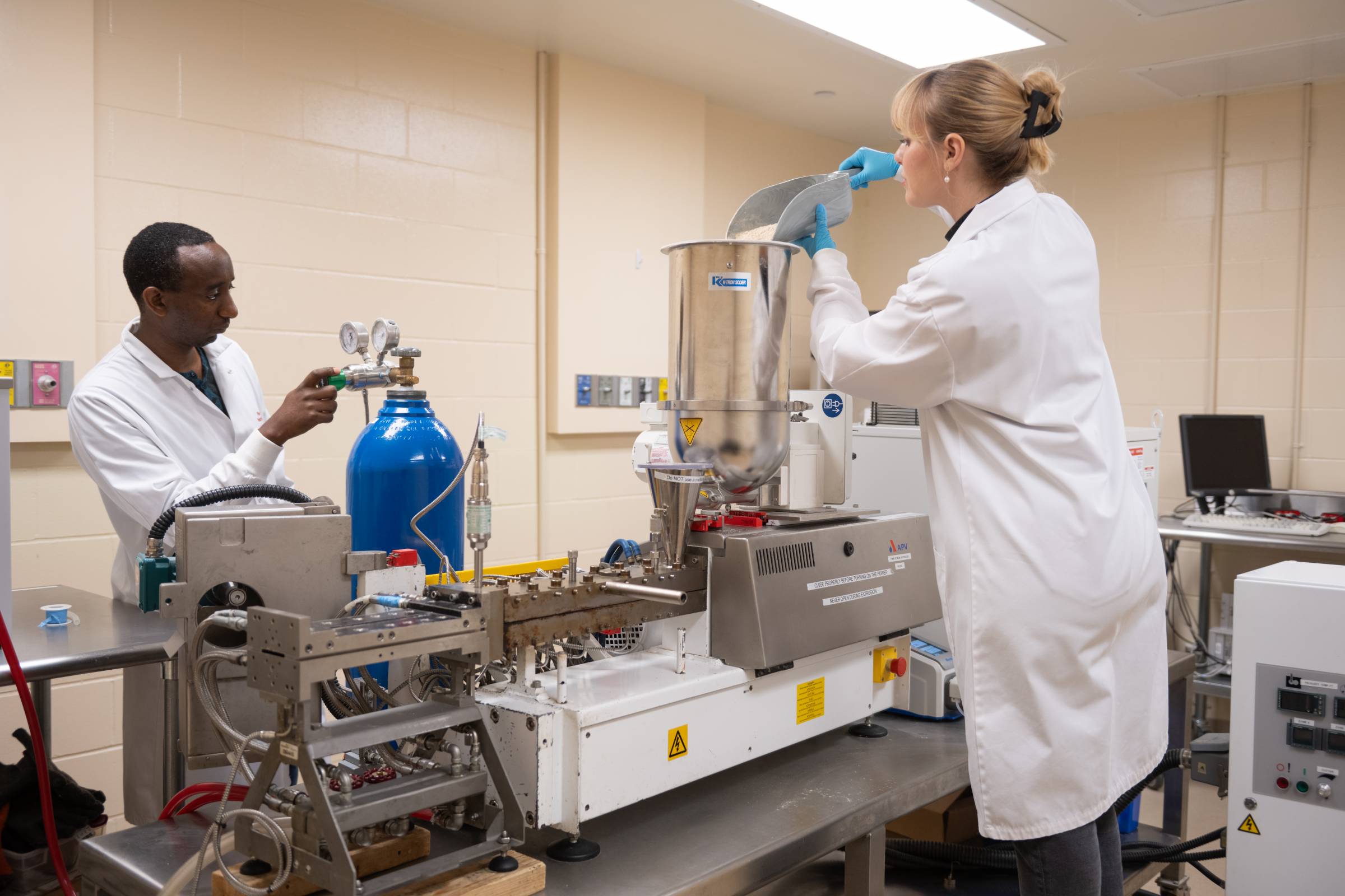 Two technicians work on equipment in a lab in the Richardson Centre.