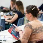 Person reading a book on academic integrity in Canada