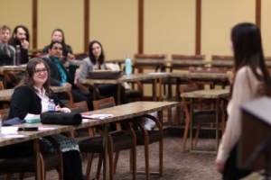A presenter stands at the front of a seated audience during a 3MT Challenge Heat.