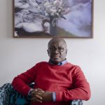 Edmund Opoku-Agyeman sitting on a couch in front for his portrait