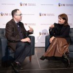 Seated in armchairs on a stage, Dr. Peter Nickerson and Dr. Kathryn Tinckam converse while holding microphones.