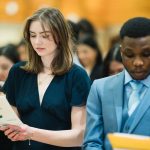 Graduands Sophie Harms and Tolulope Akinloye recite the UM Bachelor of Nursing page with their graduating class.