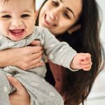 Close-up of a woman playing with her baby boy.