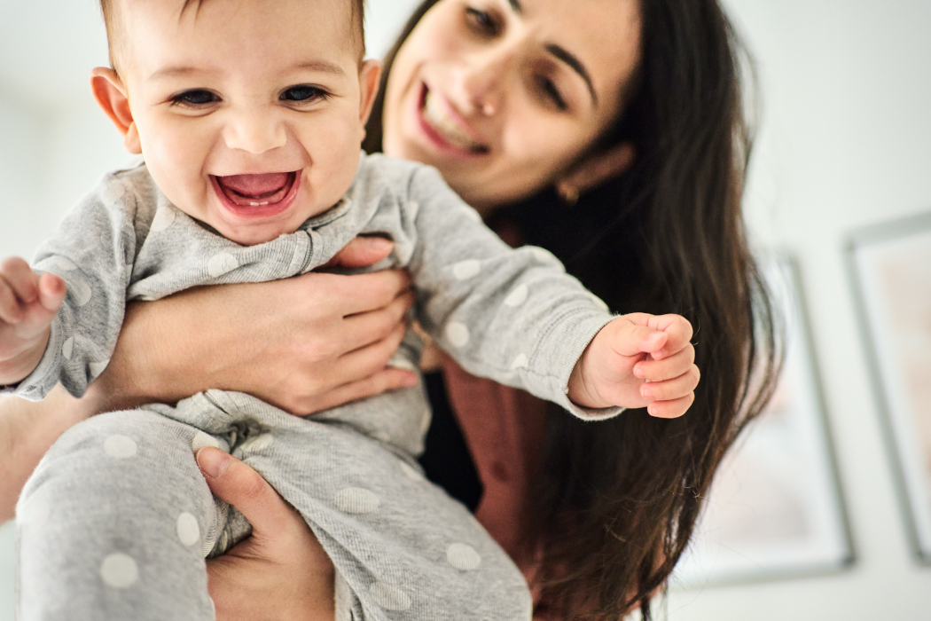 Close-up of a woman playing with her baby boy.