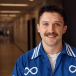 Headshot of Cameron Bouchard wearing a jacket with Metis symbols on it.