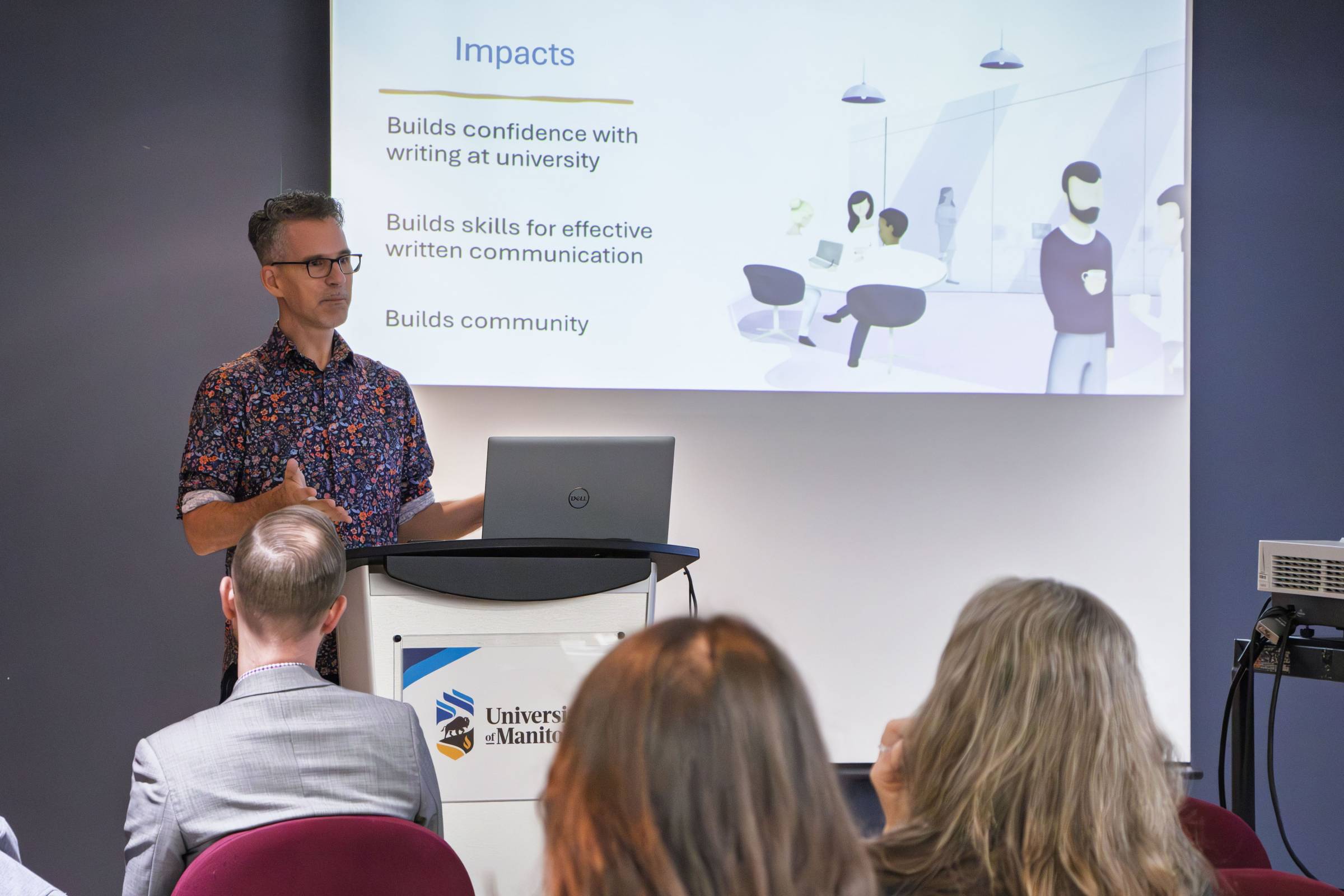 Man presenting to a classroom full of adults, using a PowerPoint presentation.