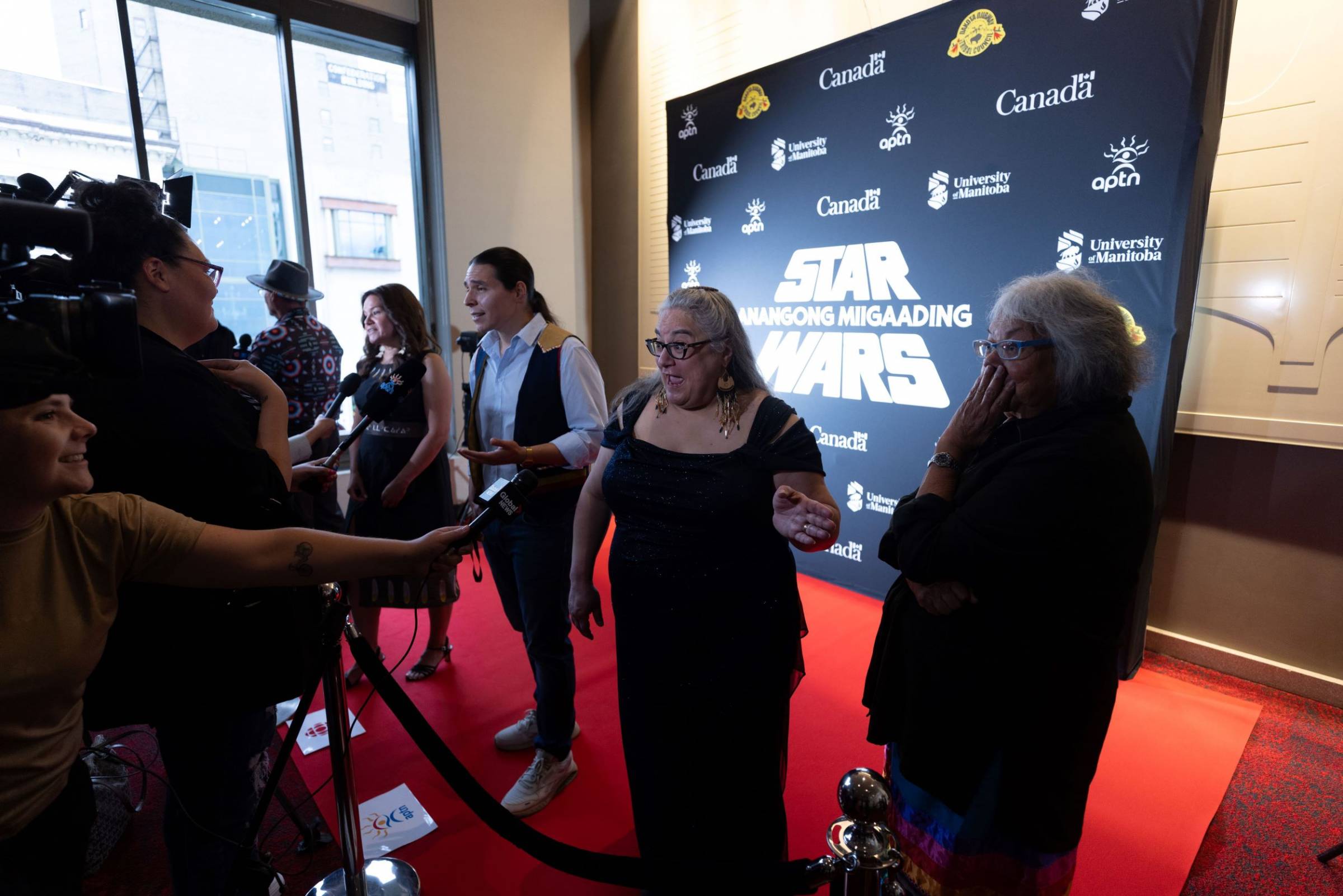 People being interviewed by media at Anishinaabemowin-dubbed Star Wars premiere.