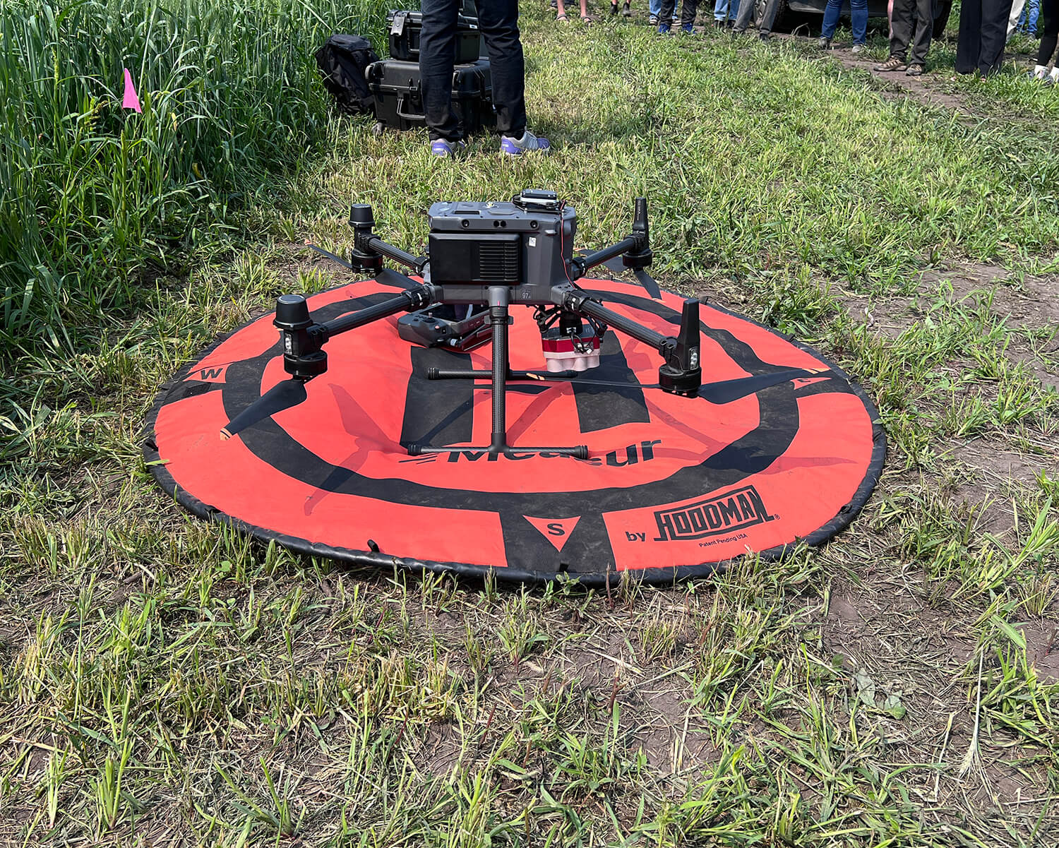 A drone rests on a red pad before being deployed