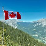Canada Flag with the Rockies in the background. Photo credit: Daniel Joseph Petty