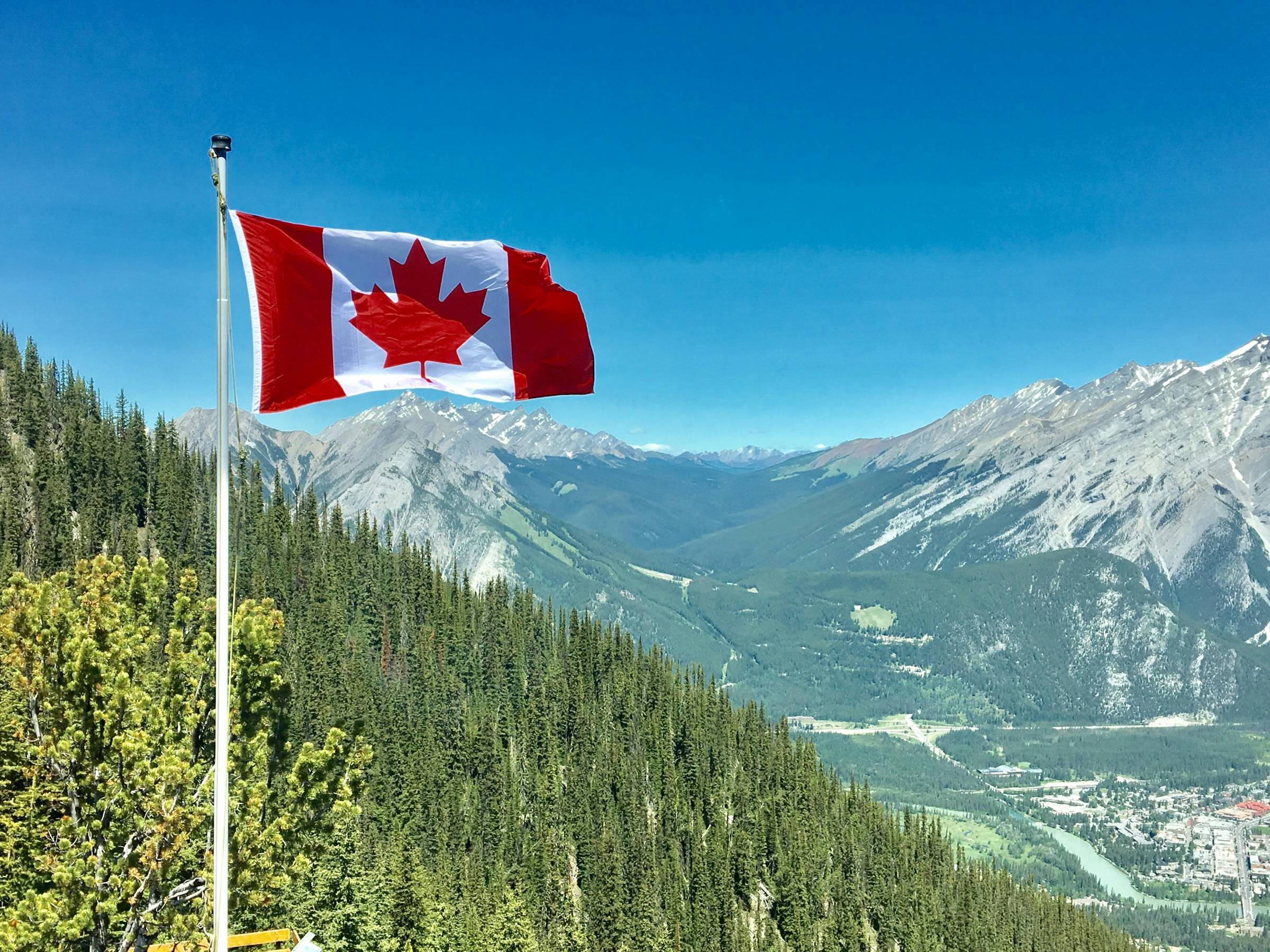 Canada Flag with the Rockies in the background. Photo credit: Daniel Joseph Petty