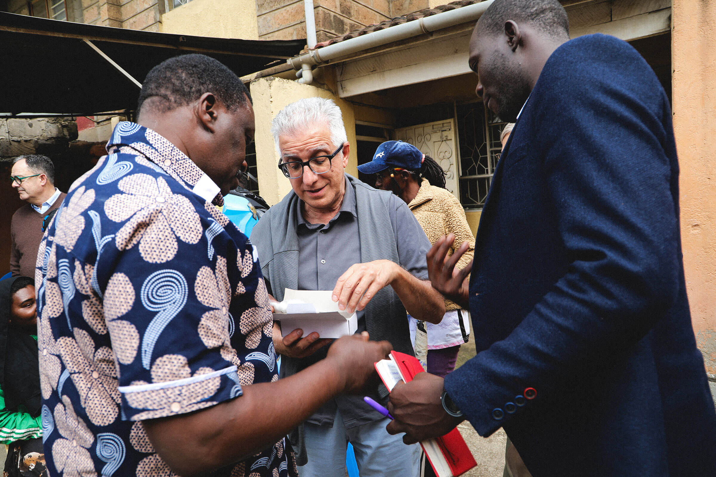 UM President Michael Benarroch is shown a clean needle kit, which peer educators hand out to drug users to help prevent the spread of HIV.