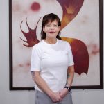 Angela Soulsby standing in font of an abstract painting