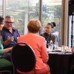 People sitting around a table discussing over a meal.