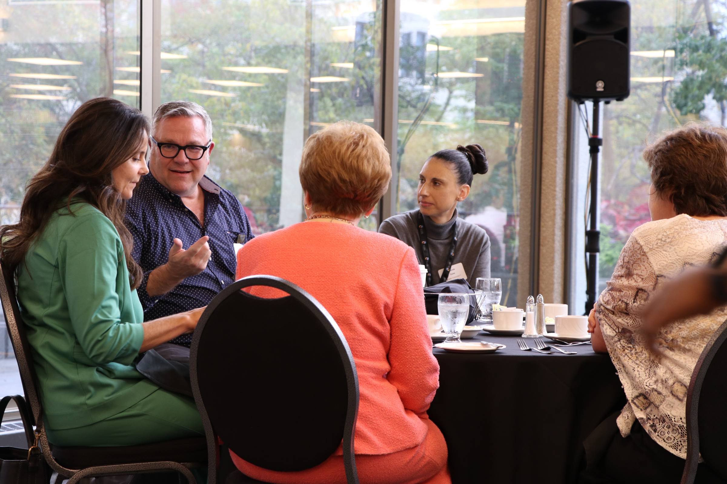People sitting around a table discussing over a meal.