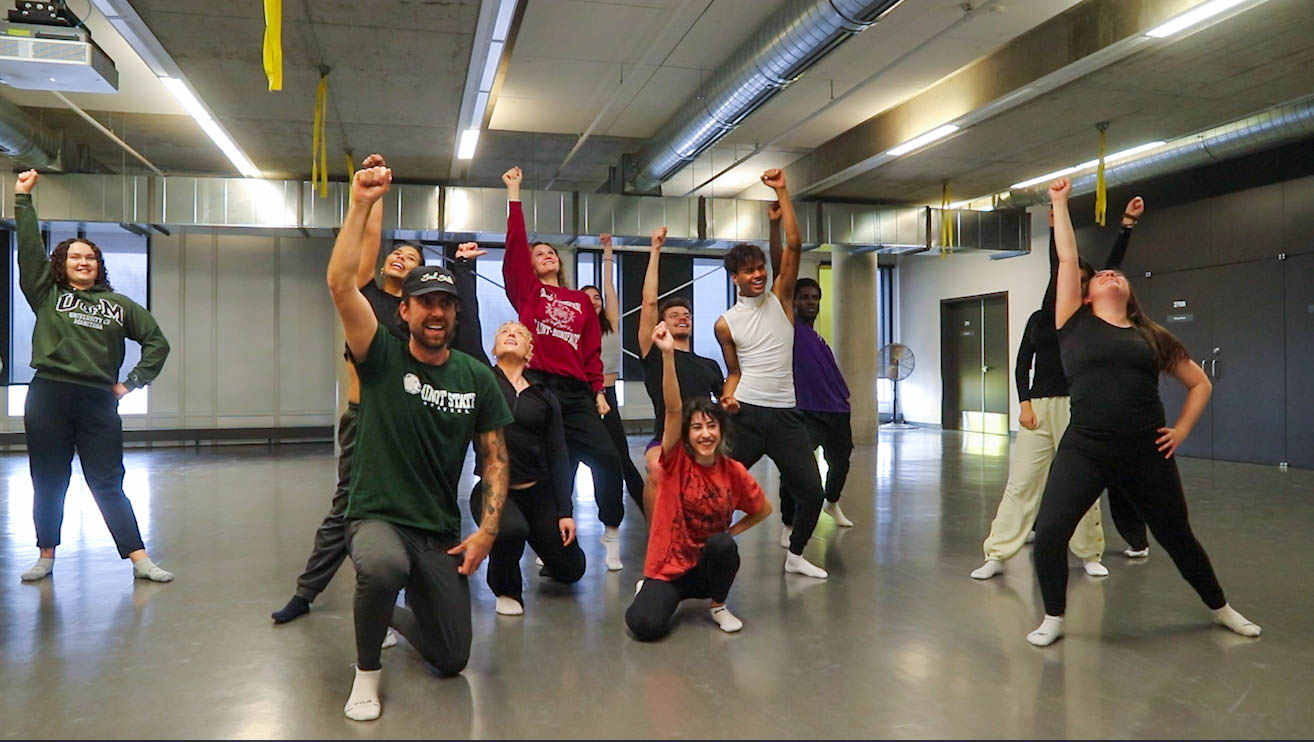 KPER 4000 students pose with their hands up at the end of a routine