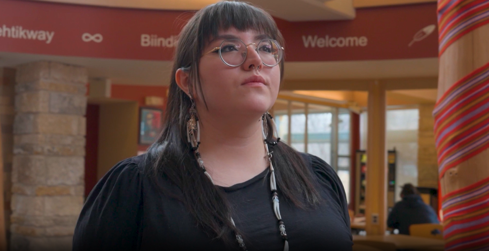 student looks ahead with black shirt, inside Indigenous student centre building