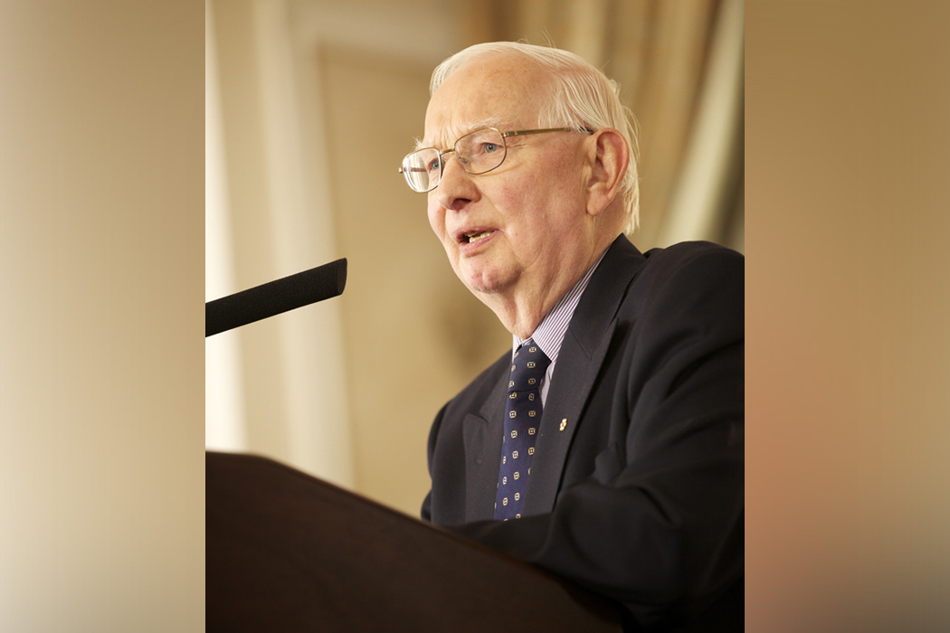 Dr. Henry Friesen speaking at a podium.