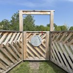 angled cedar planks creating a privacy screen with an entrance, with a silver medallion adorned