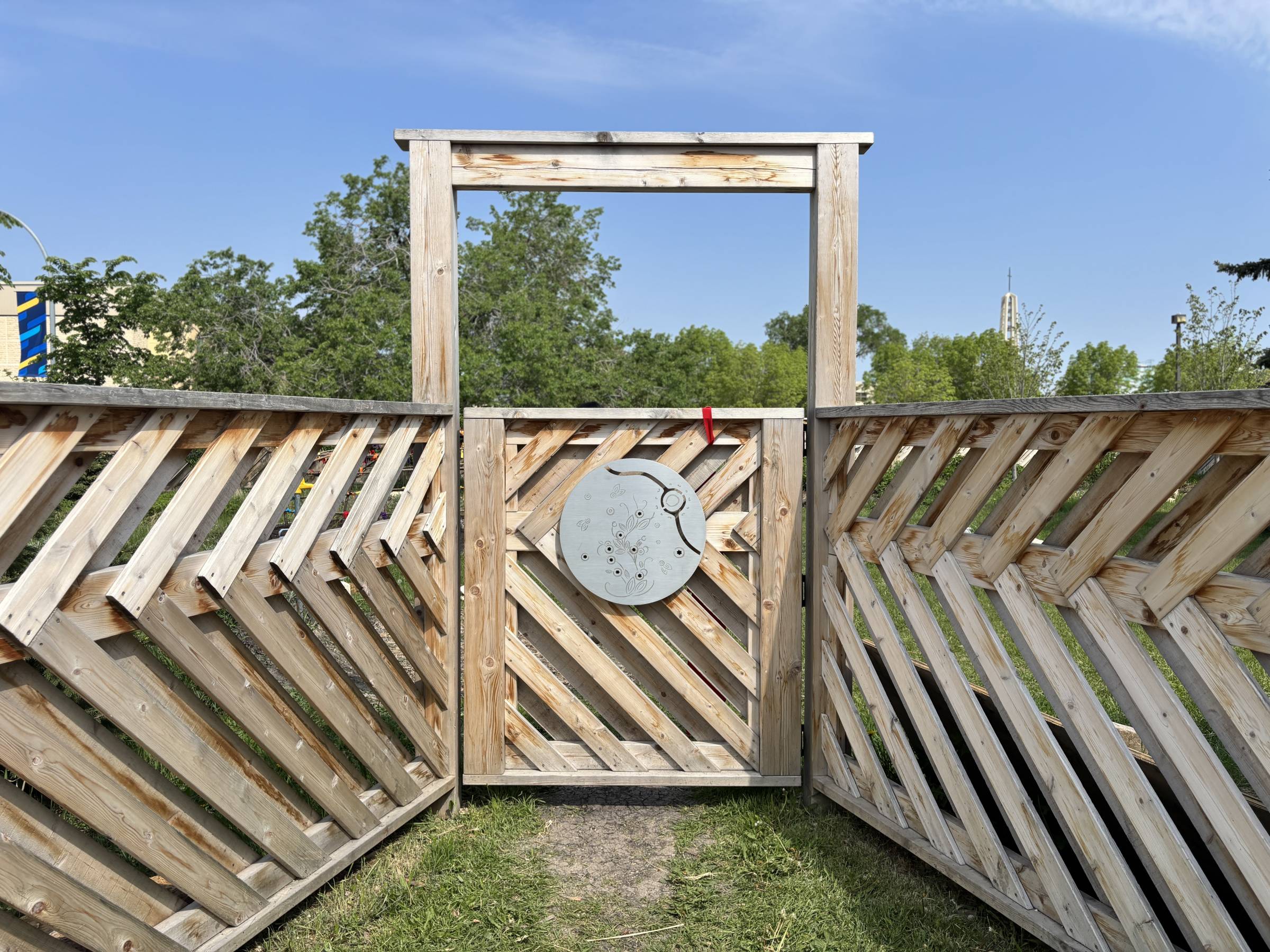 angled cedar planks creating a privacy screen with an entrance, with a silver medallion adorned