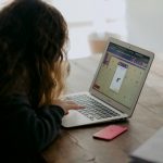 A young woman working on an online learning module on her laptop