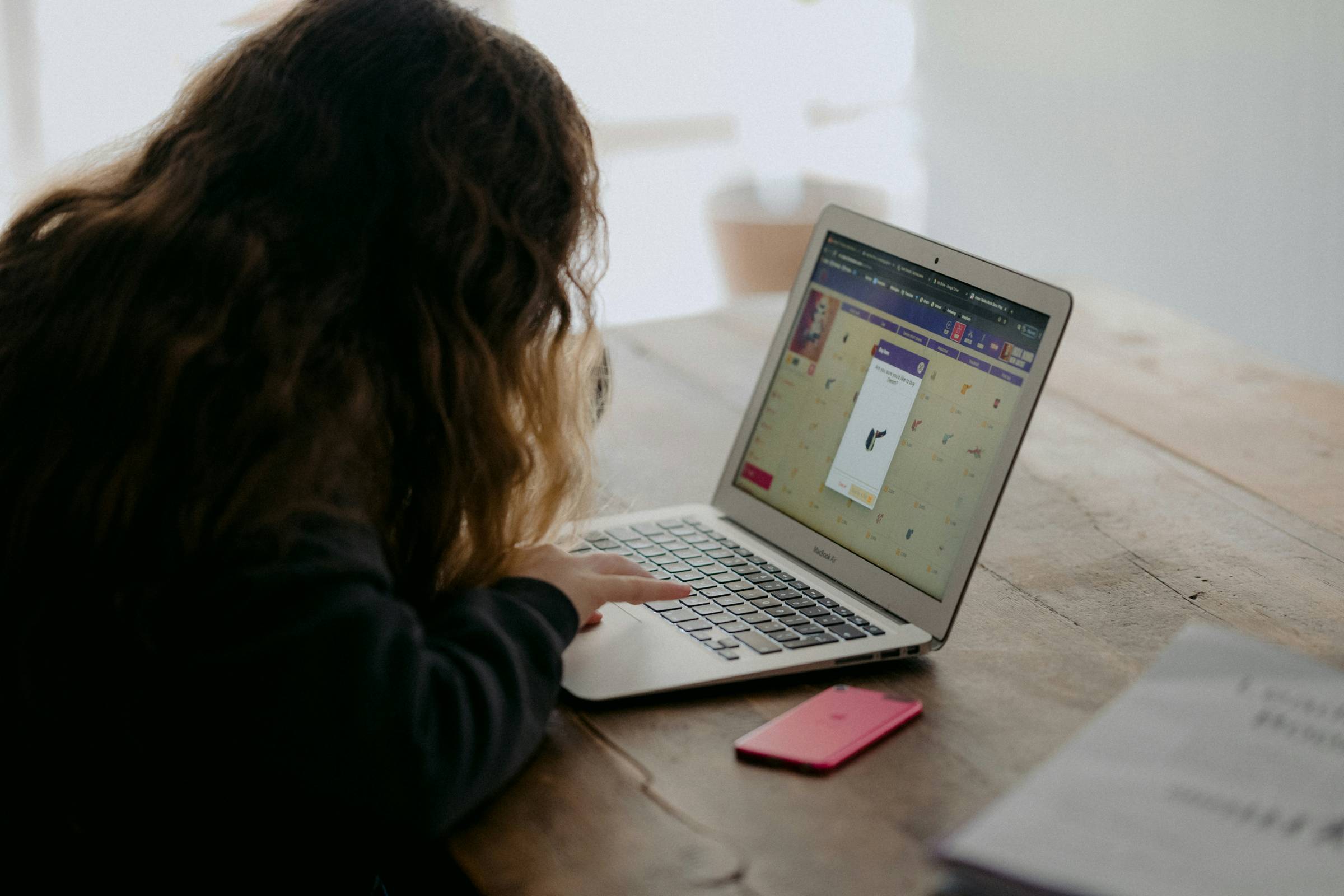 A young woman working on an online learning module on her laptop