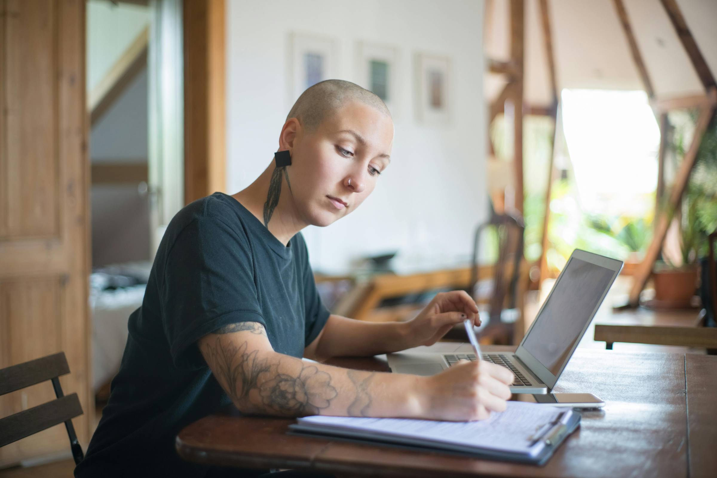 bald head femal professor working at her computer and prepping notes