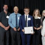 A group of educators pose with Conor McNab and his award.