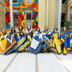 Honourees pose together, each wrapped with their star blanket