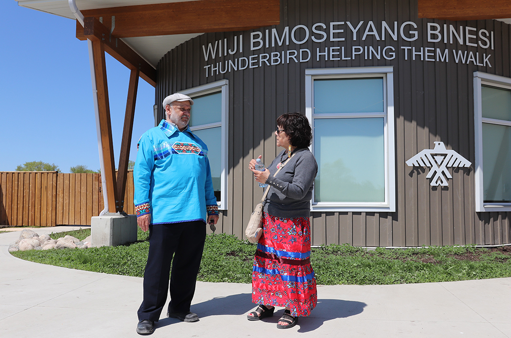 Dr. Reg Urbanowski and Audrey Henderson talk outside of the supportive housing building in Sagkeeng First Nation.