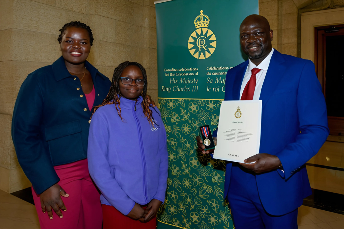 african american man holding a paper certificate with wife and daughter