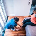 A health care professional massages a patient's foot.