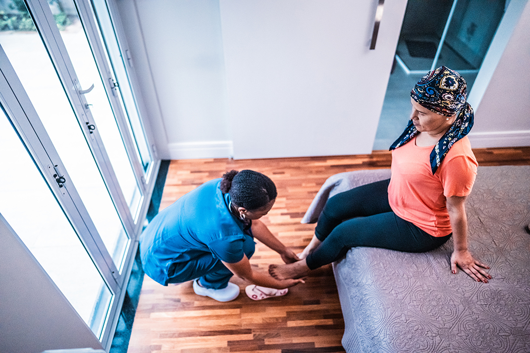 A health care professional massages a patient's foot.