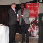 Stephen Pistorius on the stage receiving the 2025 CAP-COMP Peter Kirkby Memorial Medal.