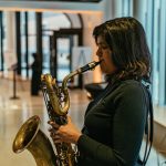 woman playing a saxophone in the Desautels Concert Hall entrance