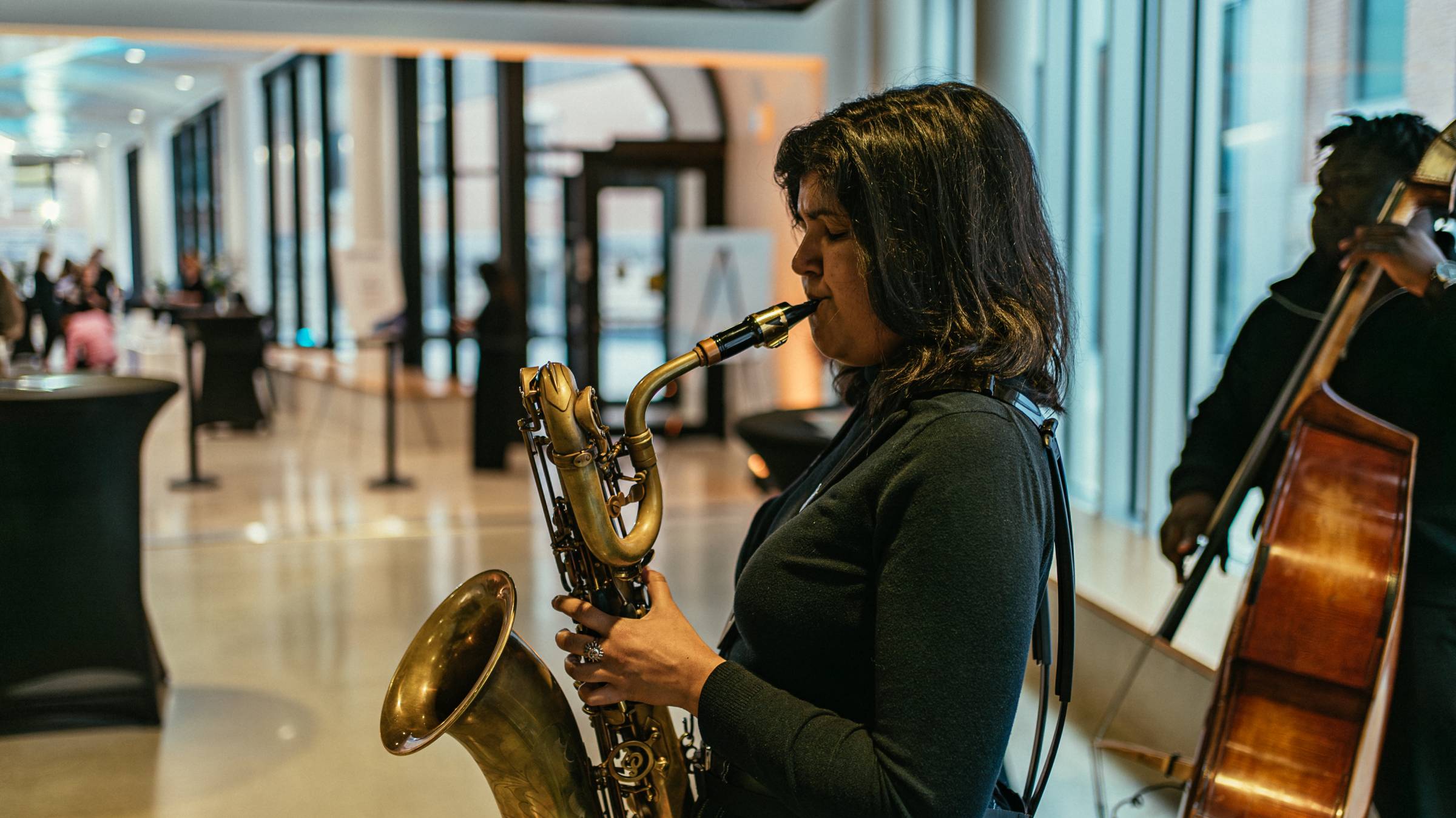 woman playing a saxophone in the Desautels Concert Hall entrance