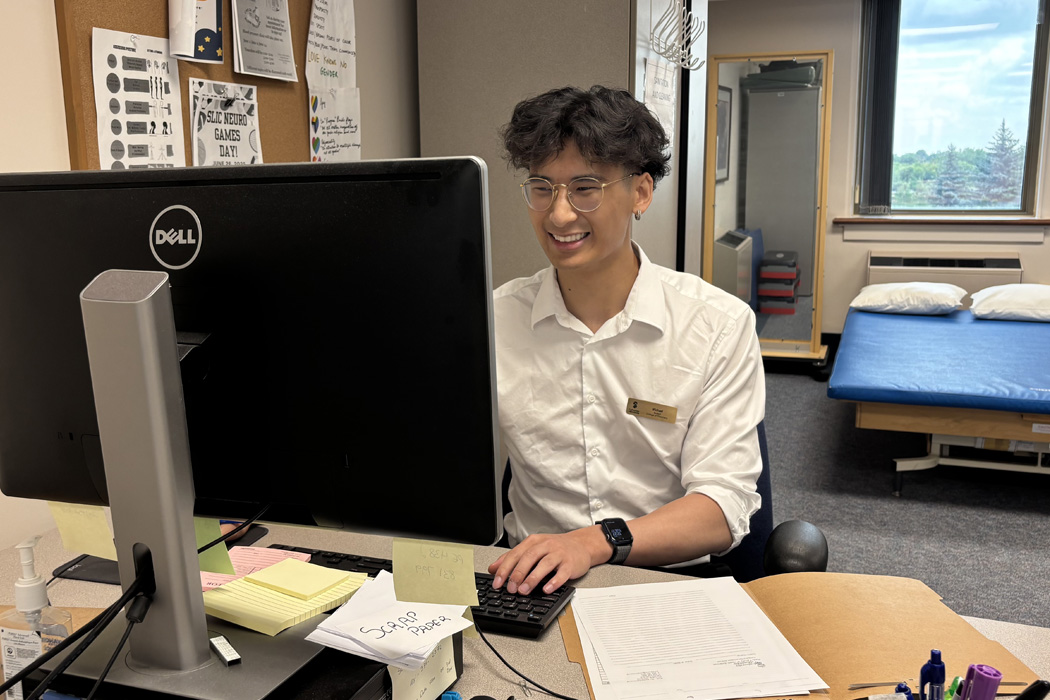 Michael Li works at a computer station in a clinic setting.