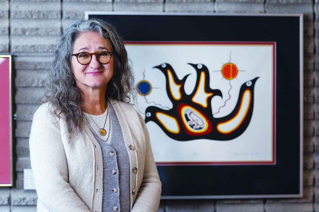 Dr. Moni Fricke with an artwork by Jackson Beardy from Garden Hill First Nation.