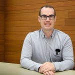 Kevin McGregor sitting behind a table and smiling at the camera.